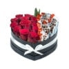 Crvene ruže u kutiji u obliku srca obavijena belom mašnom sa kinder čokoladicama na beloj pozadini