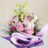 Buket cveća upakovan u papiru lila boje
