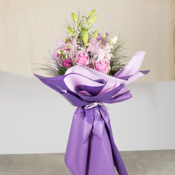 Buket cveća upakovan u papiru lila boje